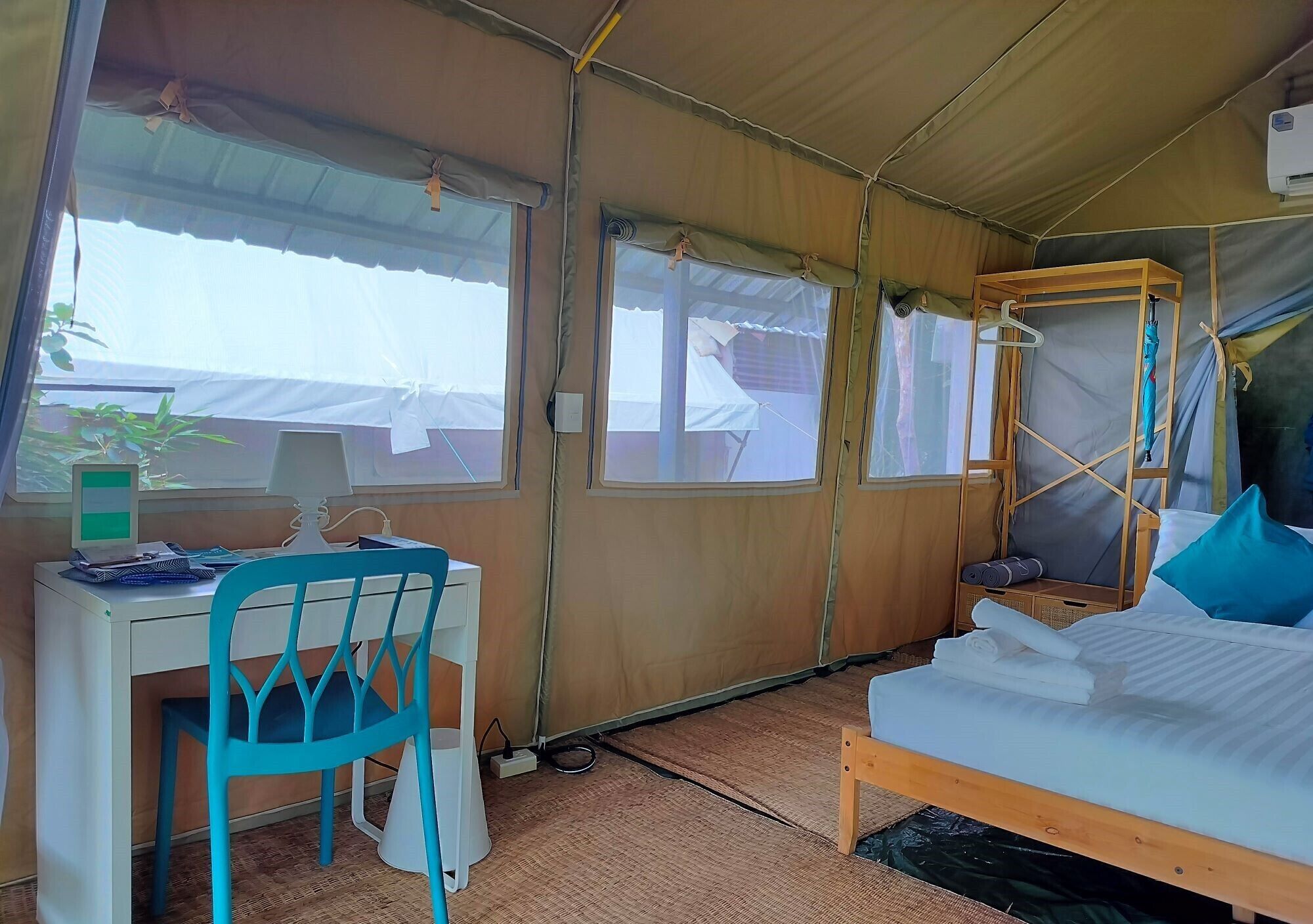 Una habitación con carpa, una cama, un escritorio y una silla.