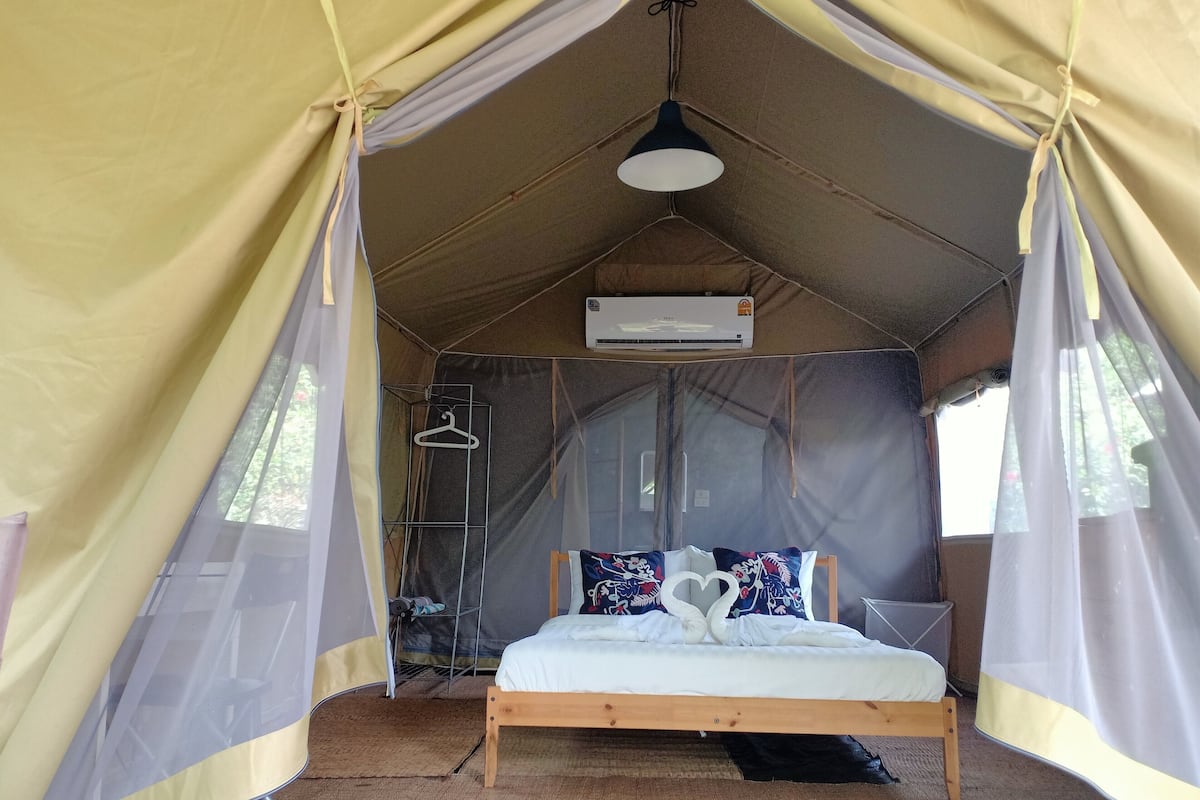 Une tente équipée d’un lit, d’une moustiquaire et d’un appareil de climatisation.