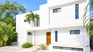 Un edificio moderno de dos pisos con techo plano, ventanas grandes y fachada blanca e impecable.