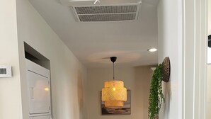 A modern kitchen with a built-in microwave, a dining table with chairs, and a hanging pendant light. - A Great Apartment In The Middle Of It All! (Nashville)