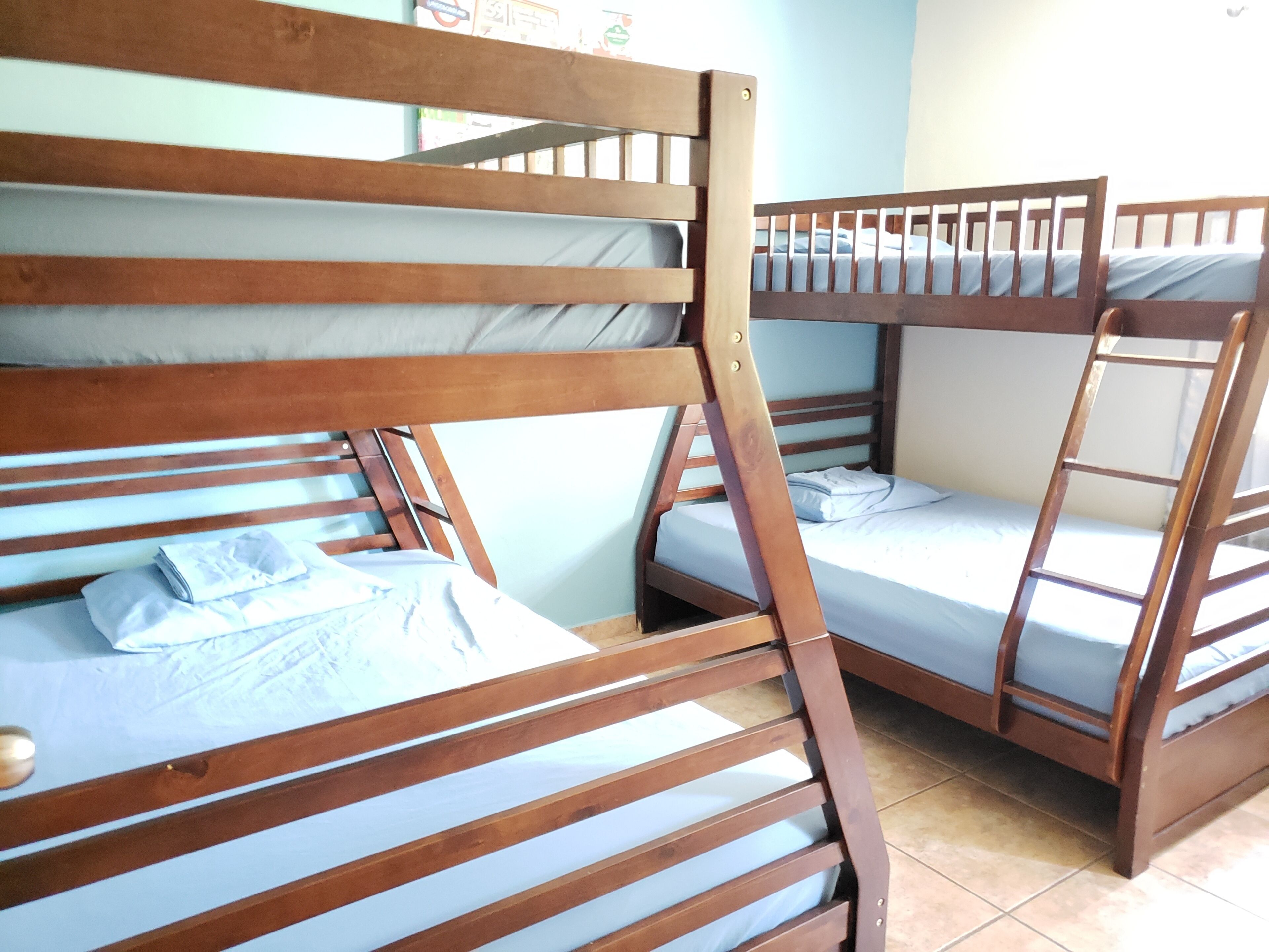 A bunk bed room with wooden frames and blue bedding.