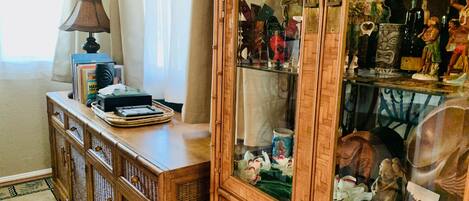 A wooden cabinet with glass doors displaying various items.