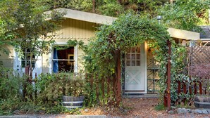 Una casa rústica con un porche de madera, una puerta y una ventana.