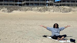 Ein Strand mit einem Holzgebäude und mehreren Balkonen im Hintergrund.