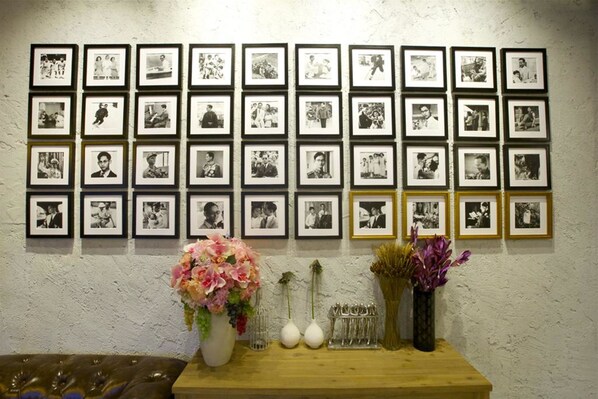 Una pared con varias fotografías enmarcadas dispuestas en forma de cuadrícula.