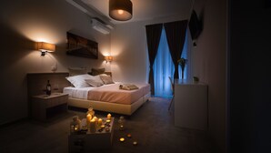 Un dormitorio moderno con cama, lámparas de noche, mesita de noche, escritorio y televisión.