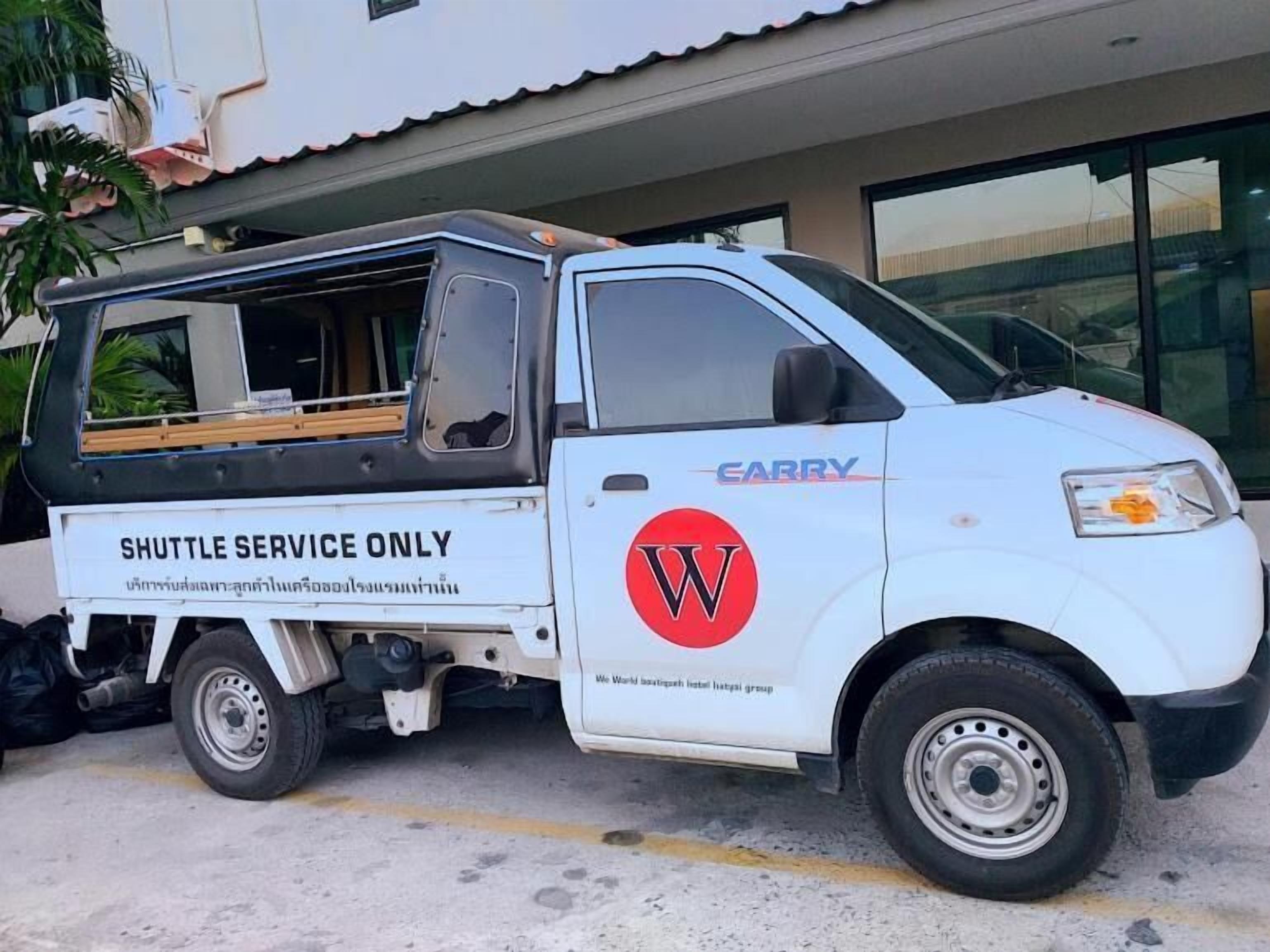 Un véhicule blanc utilisé pour un service de navette, portant une signalisation indiquant qu’il est réservé à ce service.