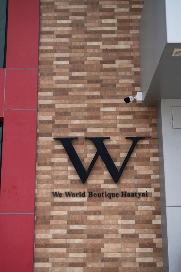 Paredes de tijolos com um grande logotipo 'W' e o texto 'We World Boutique Haayati', indicando um hotel boutique.