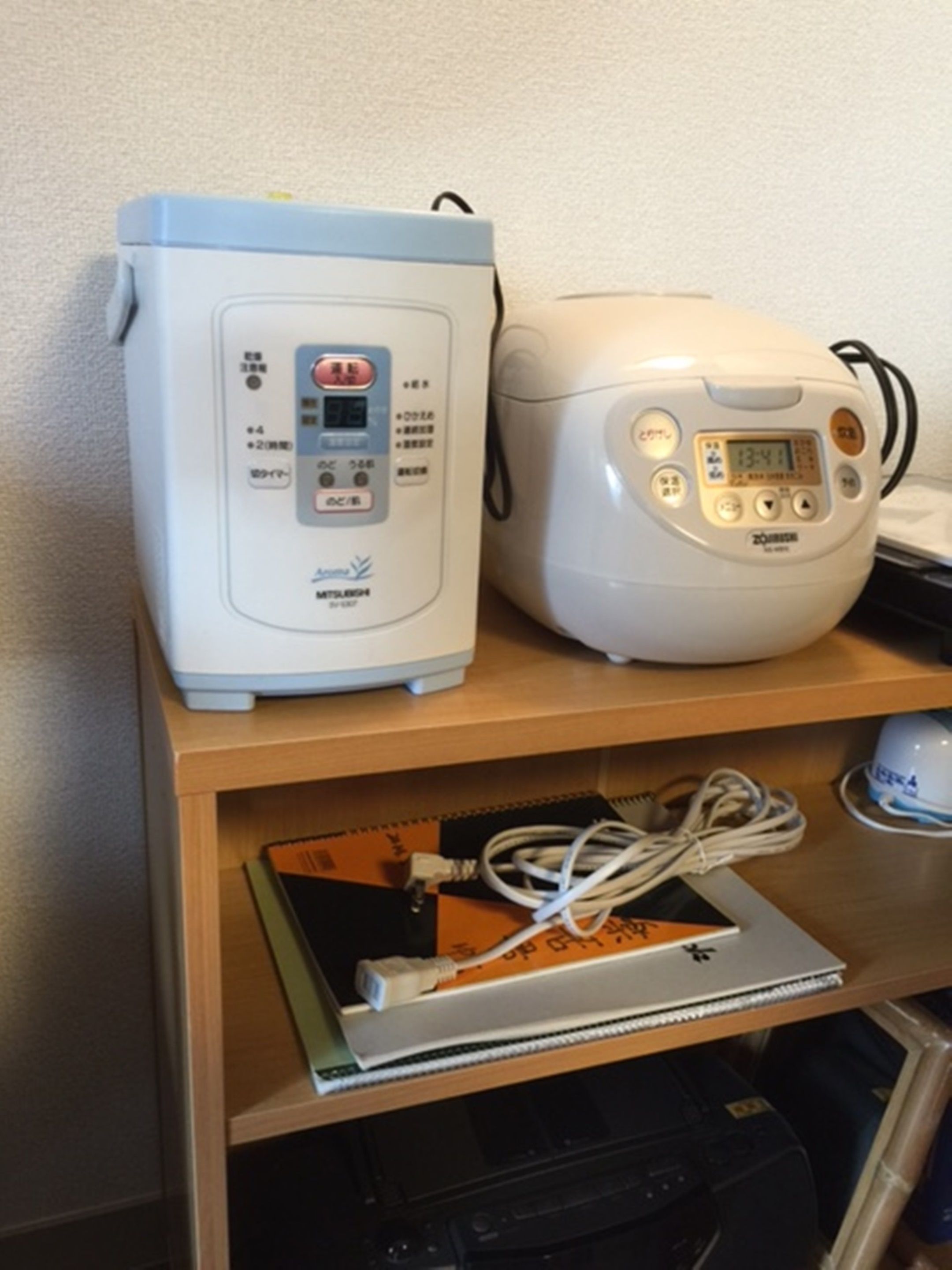 A shelf with a rice cooker and a microwave.