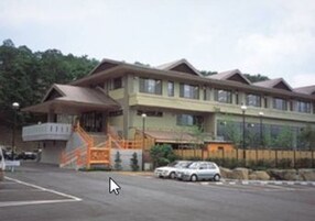 Un edificio de varios pisos con techo plano y una rampa que lleva a la entrada.