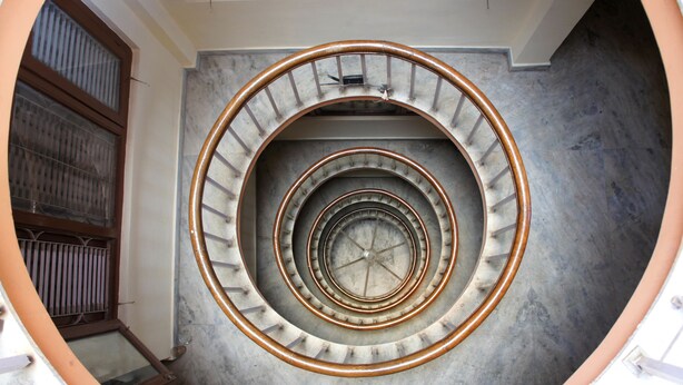 Eine Wendeltreppe mit Metallgeländer und einer Betonwand.