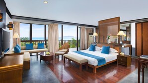 A spacious hotel room with a large bed, a seating area with a sofa and chairs, a desk, and a balcony with a view of the sea. - International Asia-Pacific Convention Center (Sanya)