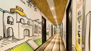 Un couloir doté d’un sol à rayures et de murs décorés de dessins d’architecture et de textes.