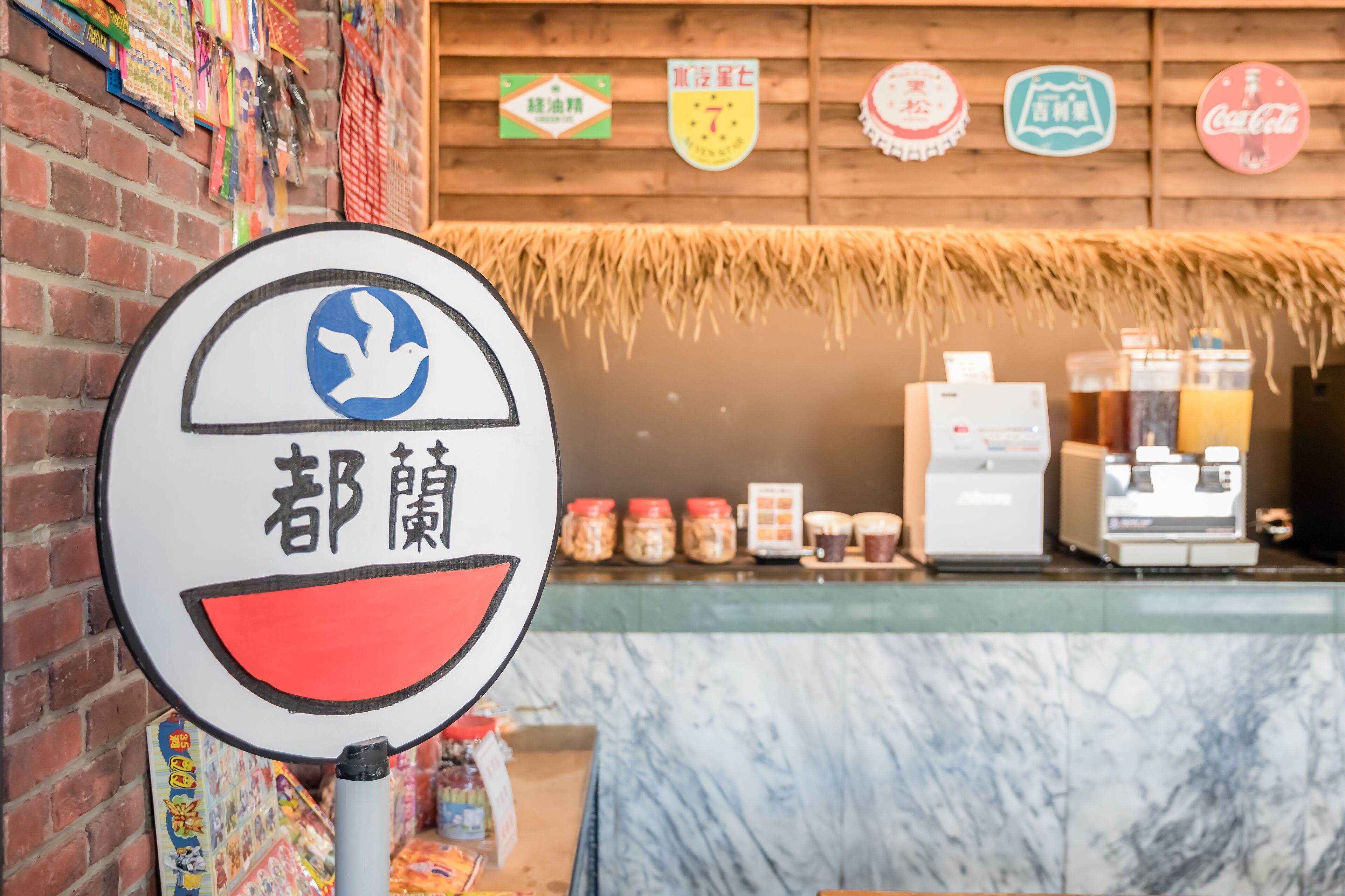 A restaurant with a counter, a Coca-Cola sign, and a sign with a bird and Chinese characters.