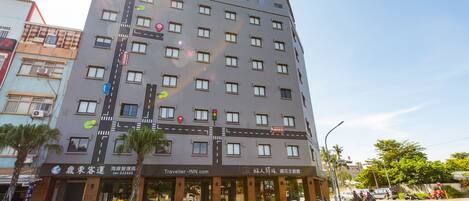 A multi-story hotel with a modern facade, featuring a prominent road sign design on the exterior.