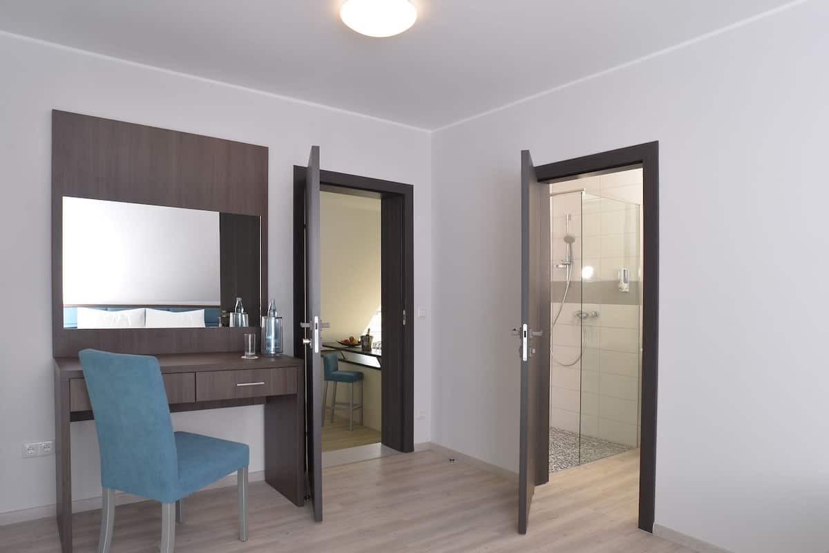 Een moderne kamer met een bureau, stoel en een douchehoek.