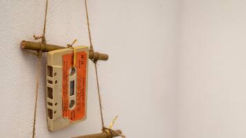 Una decoración de pared con una cinta de cassette, una piña y ramas de madera.