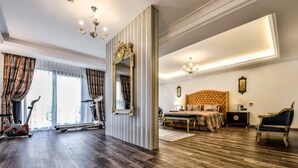 Una habitación amplia con una cama grande, un espacio para ejercitarse con equipamiento deportivo y un espejo.