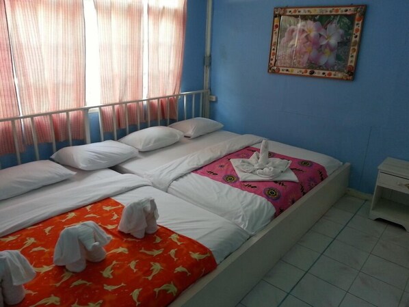 Quarto de hotel com cama, almofadas, mesa de cabeceira e um quadro na parede.