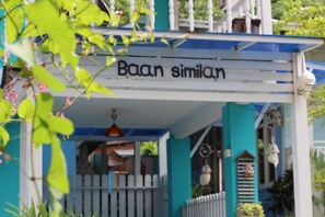 A building with a sign reading "Baan similaran" and a white picket fence.