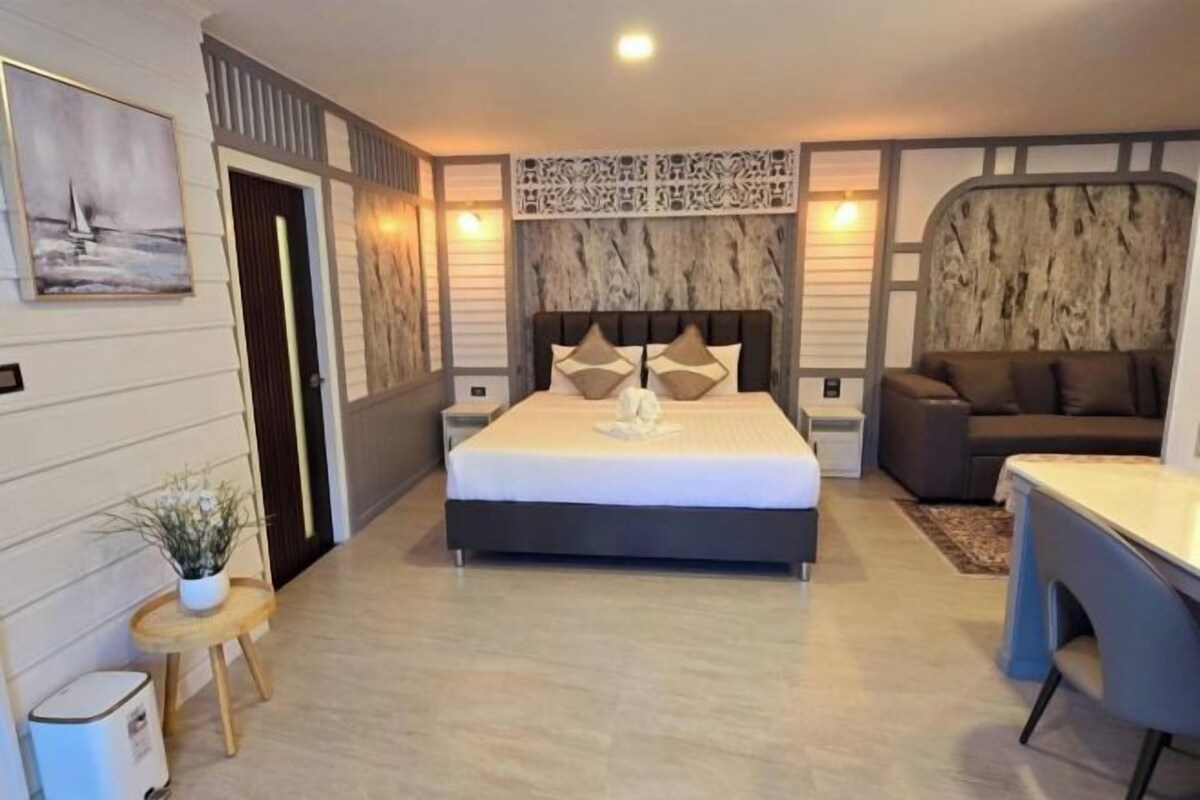 Un dormitorio moderno con una cama grande, un escritorio y un sofá.
