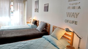 Habitación de hotel con dos camas, una pared con una cita motivacional y vista a la Torre Eiffel a través de la ventana.