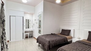 Une chambre avec deux lits, un bureau et une armoire.
