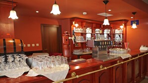 A bar area with a wooden counter, glasses, and a beer tap.