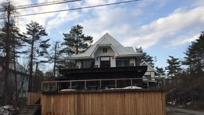 A two-story building with a balcony and a boat on top. - Powder Temple (Hakuba)