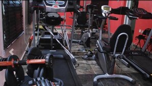 A gym with various exercise equipment including a treadmill, elliptical, and weight machines. - House 46 (Lagos)