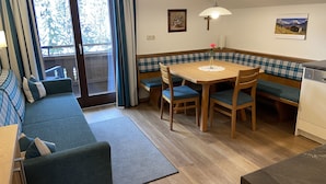 Een knus vertrek met een bank, een eettafel en een lange bank.