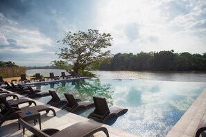 A poolside area with lounge chairs and a view of a lake. - The Farmington Hotel (Harbel)