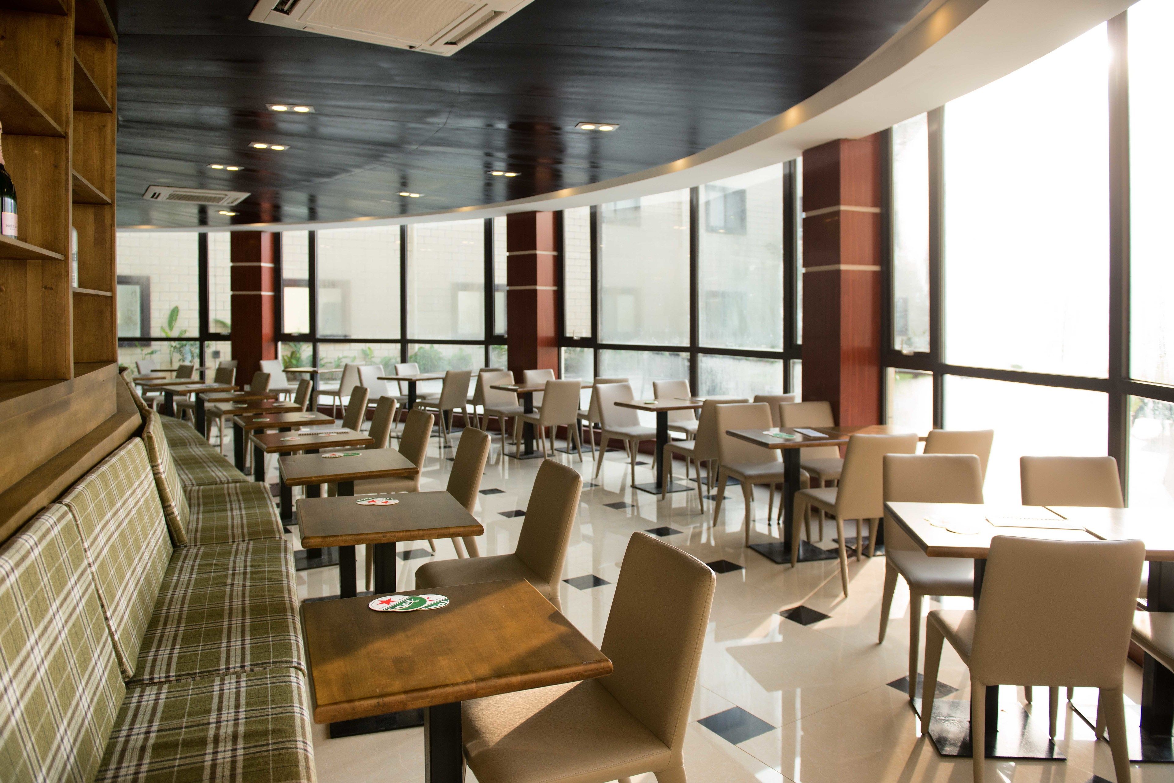 Un restaurante con techo curvo, ventanas amplias y una combinación de cabinas y mesas.
