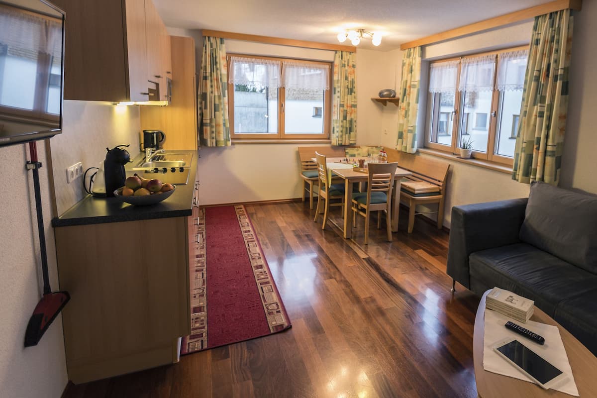 A compact living space with a kitchenette, dining area, and a sofa.