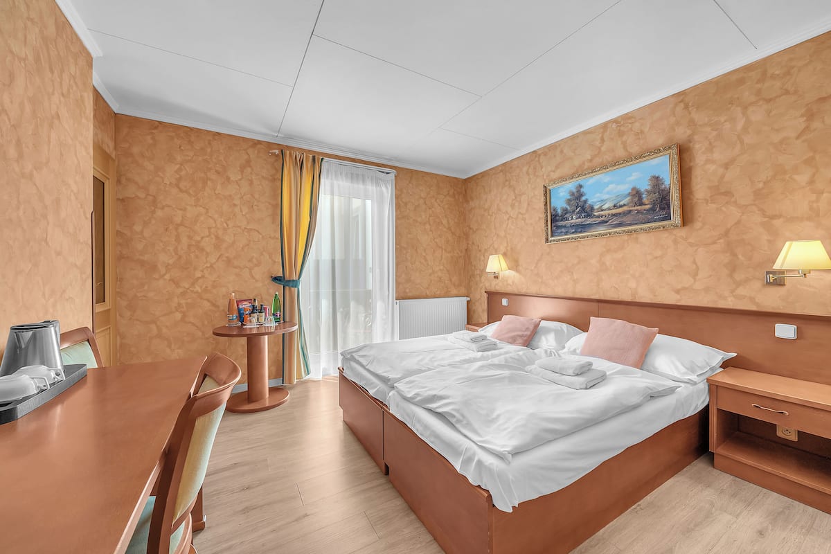 Une chambre d’hôtel avec un lit, une table de chevet, une lampe et un tableau au mur.