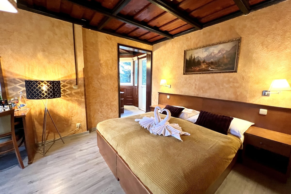 Une chambre d’hôtel avec un grand lit, un bureau avec une lampe et un tableau au mur.