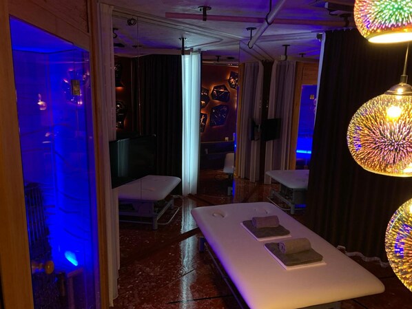 A spa room with a massage table, a glass enclosure, and a ceiling light fixture. - Smarthotel Nezvalova Archa (Olomouc)