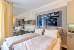 A hotel room with two beds, a desk, and a large mirror. - Smarthotel Nezvalova Archa (Olomouc)