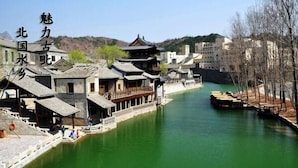 A traditional Chinese village with historic buildings along a river. - Beijing Ju Man Yuan Triditional Hotel (Miyun)