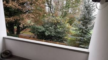 A balcony with a view of trees and a tiled floor.