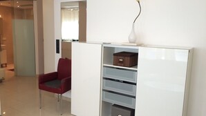 A modern room with a red chair, a white cabinet with drawers, and a vase on top. - Loft Apartment- Nähe Belvedere (Vienna)