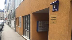 A building with a sign indicating room number 11, a nameplate for 'Manfred Moog, Steuerberater, 1. Stock', and a blue sign above the door. - Loft Apartment- Nähe Belvedere (Vienna)