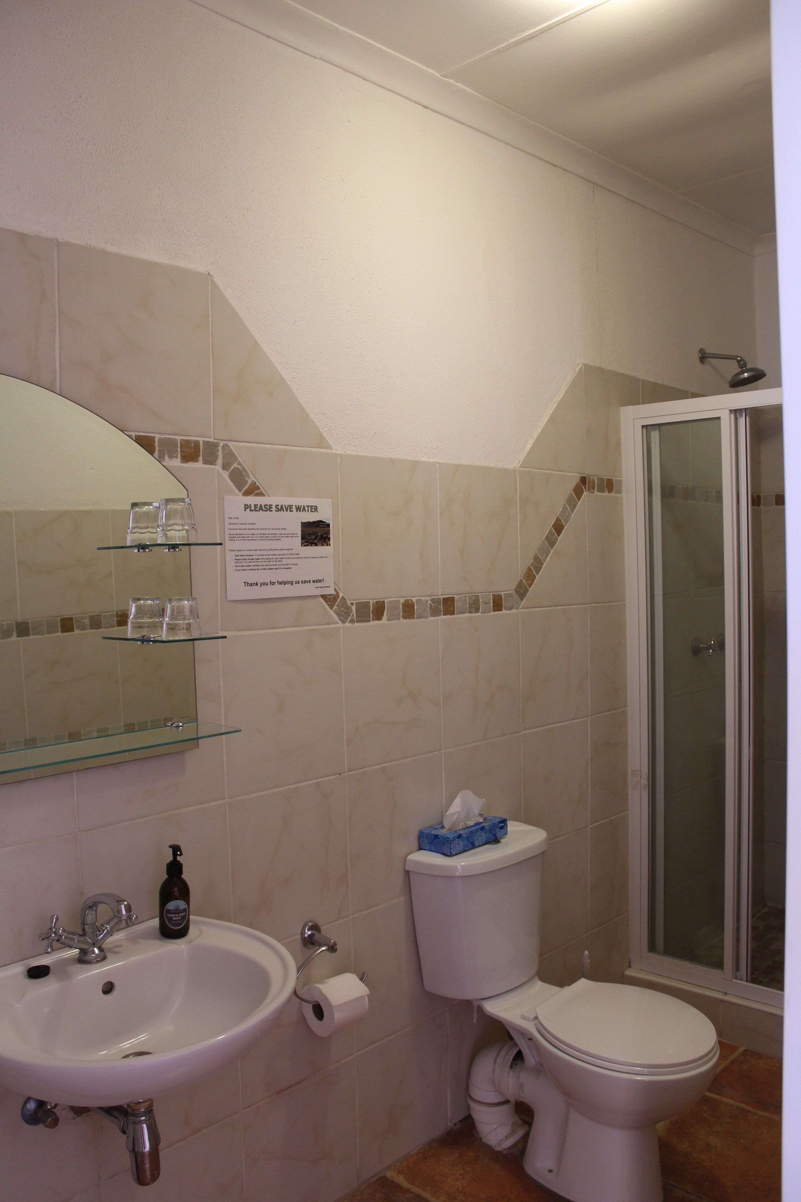 Une salle de bain équipée d’un lavabo, de toilettes et d’une douche à parois en verre.