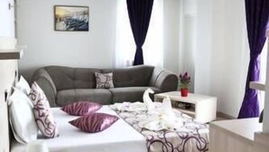 A modern bedroom with a bed, a sofa, a small table, and a nightstand. - Vila Kharisma (Navodari)