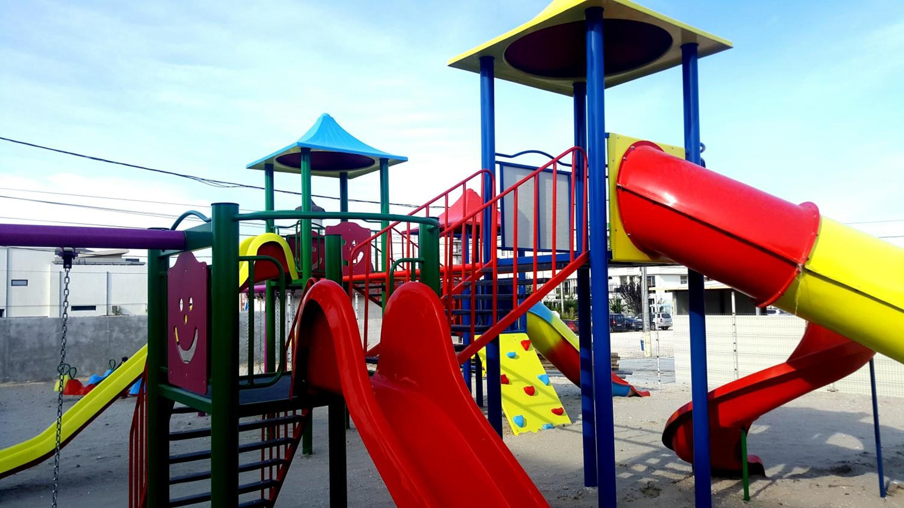 Une aire de jeux dotée de plusieurs toboggans et d’installations d’escalade.