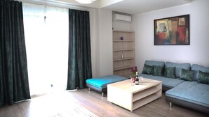 A modern living room with a sofa, a coffee table, and a bookshelf. - Vila Kharisma (Navodari)