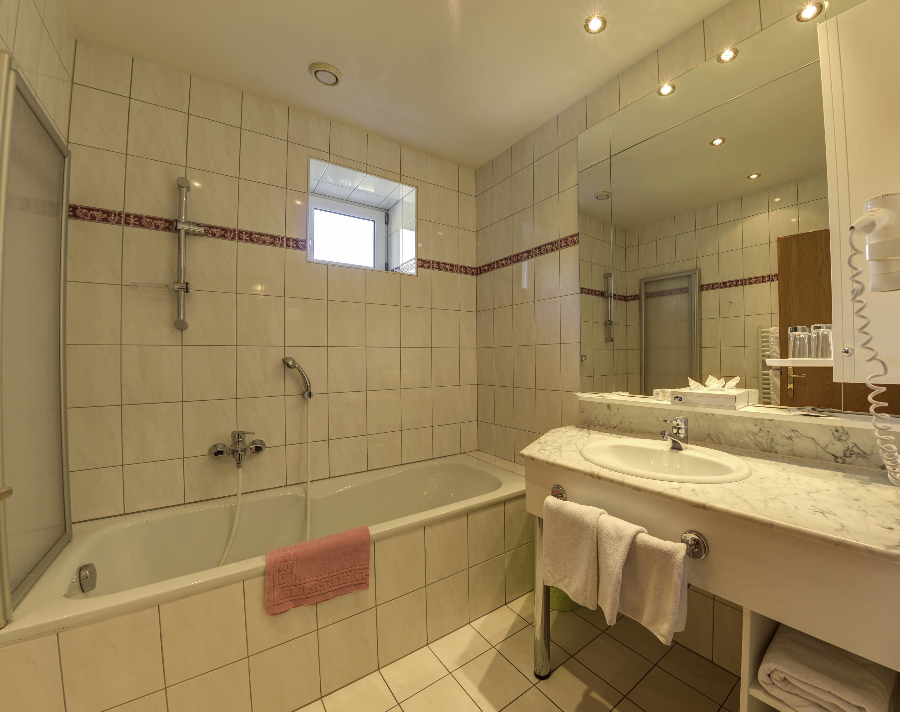 Un baño moderno con bañera, lavamanos y ducha.