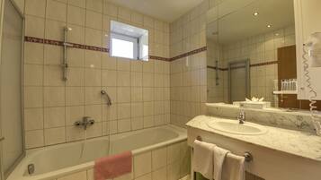 Un baño moderno con bañera, lavamanos y ducha.