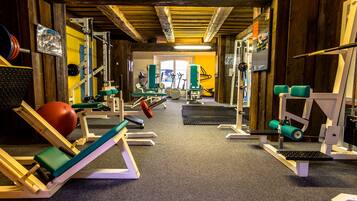 A gym with various exercise equipment, including weight machines, a treadmill, and a stationary bike.