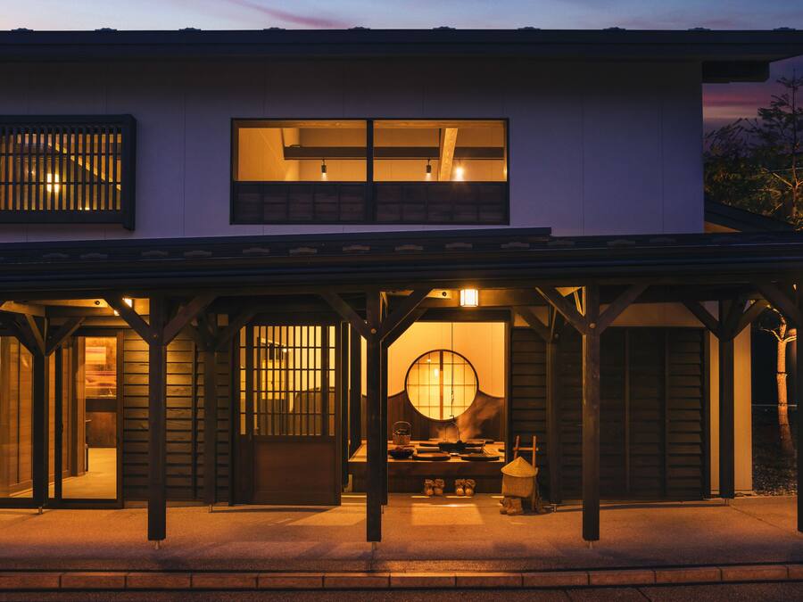 Uma casa japonesa tradicional com entrada coberta, portas de correr e uma janela circular.